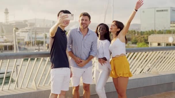 快乐的多种族朋友站在海港外，一边用智能手机自私自利 — 图库视频影像
