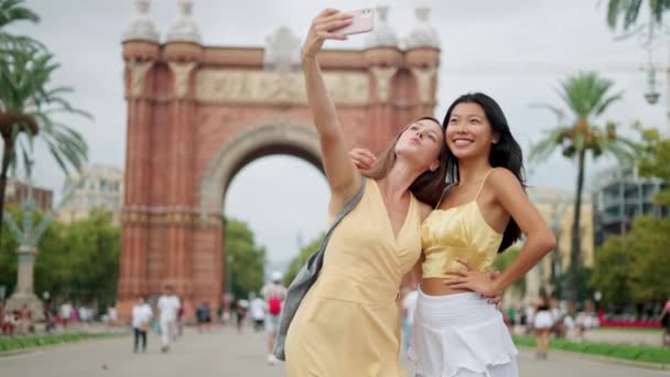Leende blandras kvinnor som tar selfie eller skytte blogg samtidigt ha kul utomhus på sommaren — Stockvideo