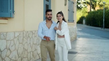 Mutlu etnik çift şehir yolunda yürürken konuşuyor.