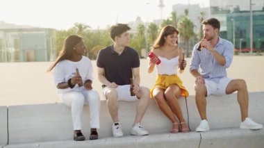 Dört çok ırklı insan, günbatımında müzik dinleyip bira içen en en iyi arkadaşlar.