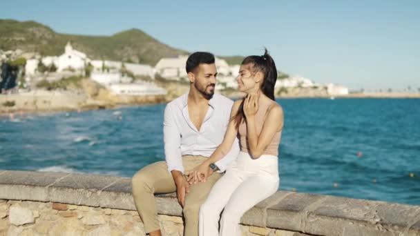 Χαμογελώντας ισπανόφωνο ζευγάρι μιλάμε ενώ στηρίζεται σε ανάχωμα — Αρχείο Βίντεο