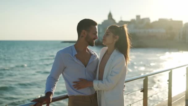 Hispanic couple kissing and talking against sea in town — Stock Video