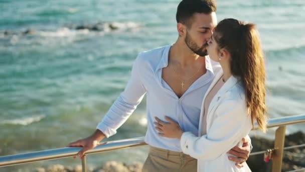 Spanisches Paar küsst und umarmt sich vor glänzendem Meer — Stockvideo
