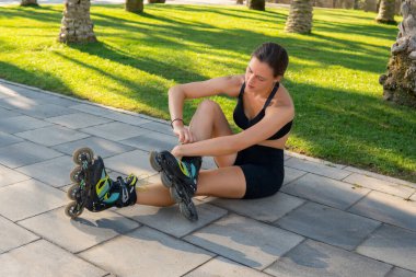 Sporcu kadın paten sürmeye hazırlanıyor.