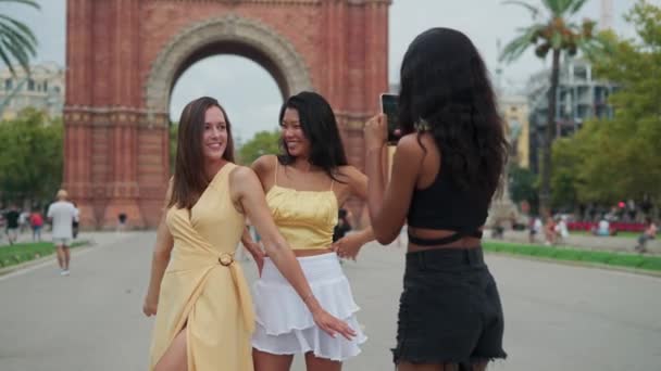 Três jovens mulheres multirraciais alegres amigos se divertindo e fotografando perto de marco famoso — Vídeo de Stock