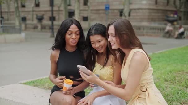 Três amigas diversas fazendo selfie no smartphone ao ar livre e escolhendo o melhor tiro — Vídeo de Stock