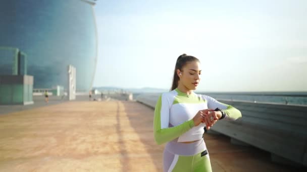 도주중에 똑똑 한 시계를 사용하는 스포츠 여자 — 비디오