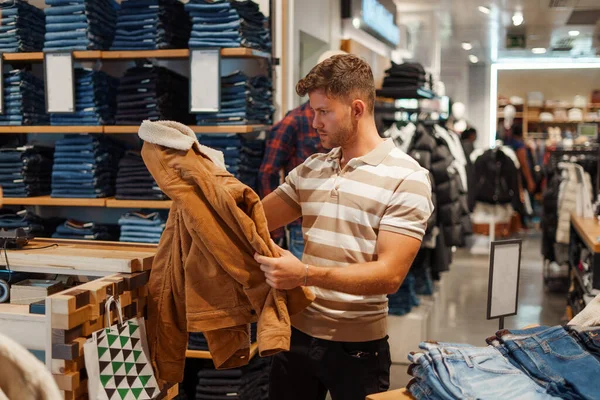 Homem comprando jaqueta quente na loja — Fotografia de Stock
