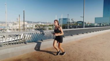 Spor kadını sabah limana yakın koşuyor.