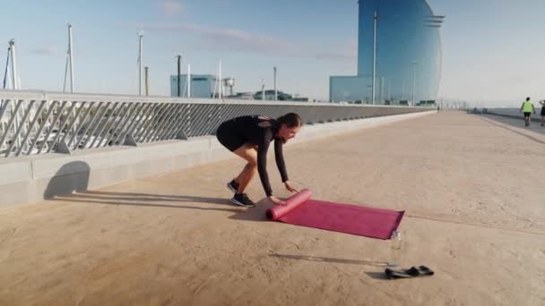 Mujer rodando hasta yoga mat — Vídeo de stock