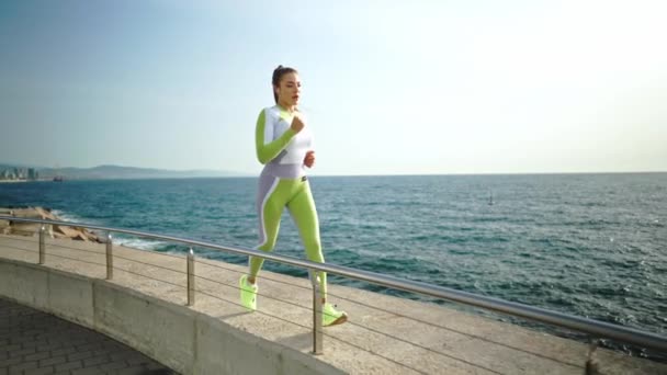 Спортсменка бежит по границе у моря — стоковое видео