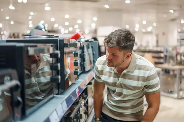 Cliente masculino seleccionando horno microondas — Foto de Stock