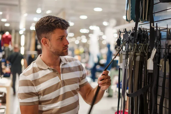 Cliente masculino escolhendo cinto na loja — Fotografia de Stock