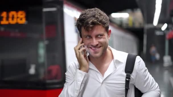 Happy male entrepreneur speaking on cellphone on station — Stock Video