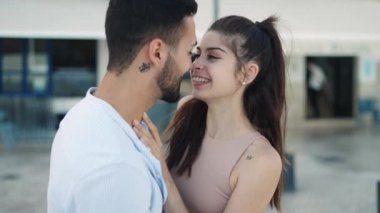 Gülümseyen İspanyol çift sokakta konuşuyor ve öpüşüyor.