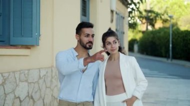 Gülümseyen İspanyol çift sokakta konuşurken el ele tutuşuyorlar.