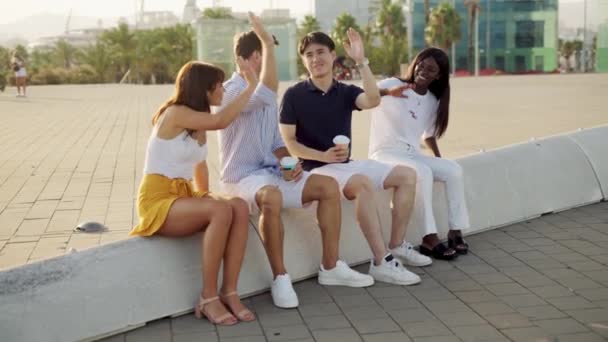 Multiraciale gelukkige vrienden geven high five en glimlachen met afhaalkoffie in handen op zomerdag — Stockvideo
