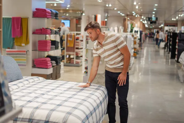 Cliente masculino verificando cobertor na cama — Fotografia de Stock