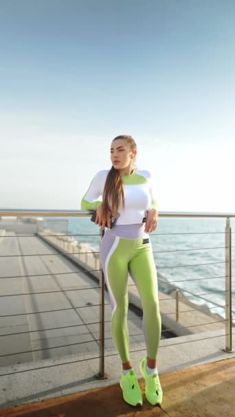 Юная спортсменка отдыхает на набережной — стоковое видео