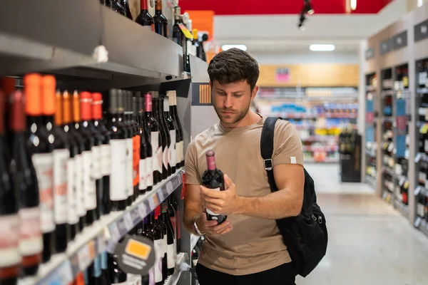 Hombre comprando vino en la tienda — Foto de Stock