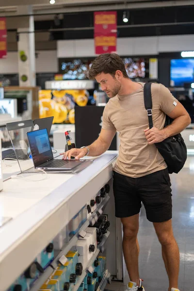 Hombre recogiendo nuevo ordenador portátil en la tienda — Foto de Stock