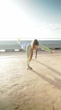 Korkulukların yanında egzersiz yapan esnek bir sporcu kadın.