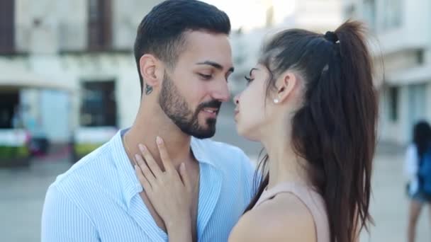 Sonriendo pareja hispana hablando y besándose en la calle — Vídeos de Stock