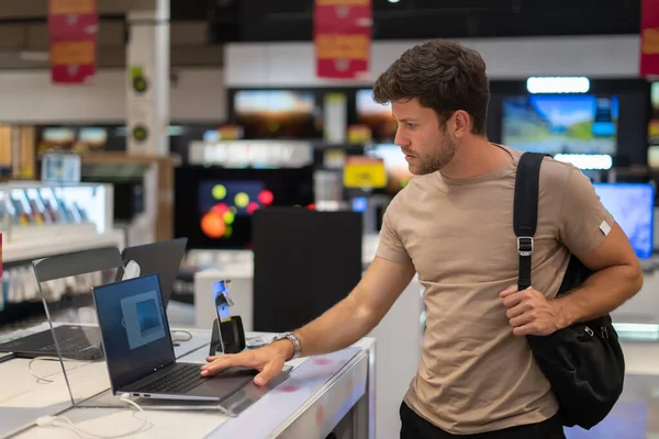 Cliente masculino explorando nuevo netbook en la tienda — Foto de Stock
