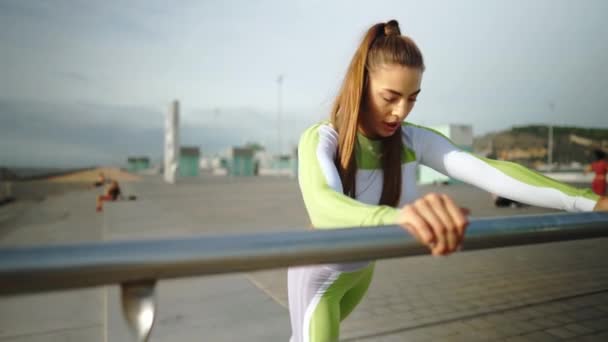 Flexibele sportvrouw die bijna railing traint — Stockvideo