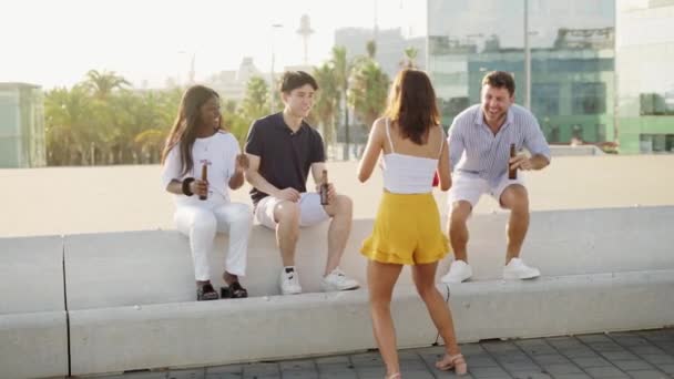 Mujer feliz joven con altavoz bluetooth musical inalámbrico en la mano bailando con un amigo al aire libre — Vídeo de stock