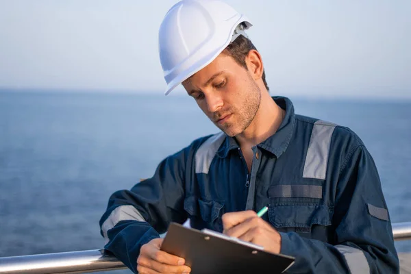 Ingeniero con portapapeles trabajando en puerto — Foto de Stock