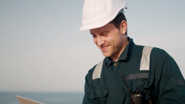 Mladý usměvavý námořník stojí na palubě lodi nebo lodi a mluví s rodinou on-line na notebooku — Stock video