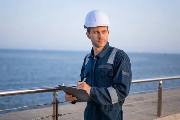 Man ingenieur met klembord op pier — Stockfoto