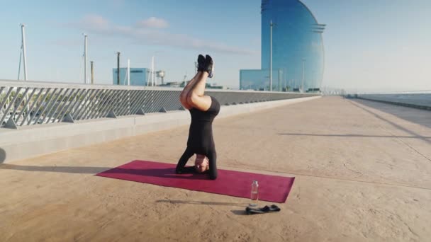 Woman doing Salamba Sirsasana on mat — Stock Video