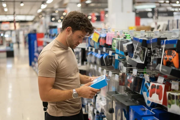 Hombre eligiendo gamepad en tienda — Foto de Stock