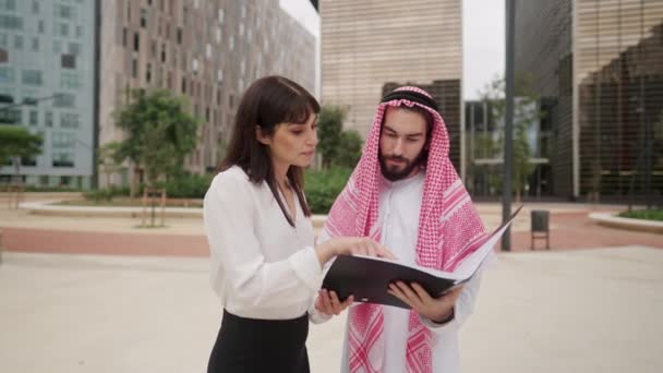 Podnikatelka zobrazující dokumenty arabskému klientovi — Stock video