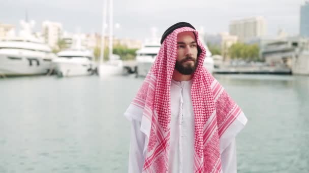 Arab male looking away in harbor — Stock video