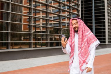 Sokakta cep telefonu kullanan Arap erkek.