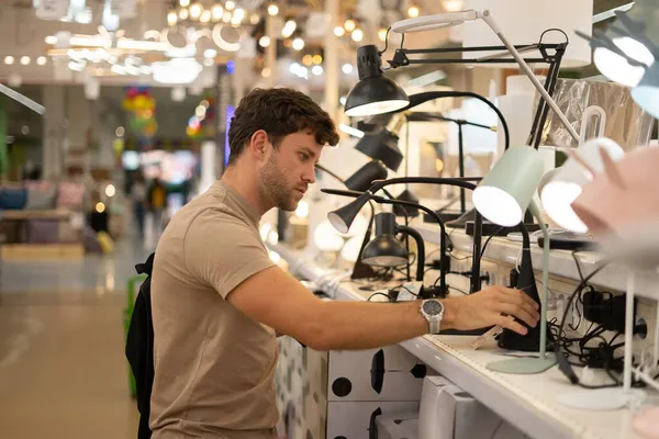 Masculino comprador escolher lâmpada no shopping — Fotografia de Stock