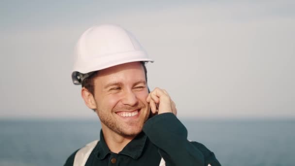 Joven oficial de cubierta marina feliz hablando con la familia o amigos en el teléfono móvil amd sonriendo — Vídeos de Stock