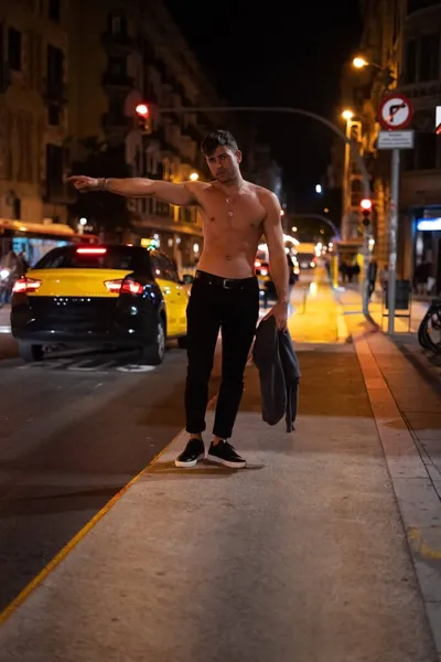 Un hombre sin camisa llamando a un taxi por la noche — Foto de Stock