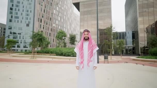 Zoom of happy smiling arabian man standing on city street, looking at camera — Stock Video