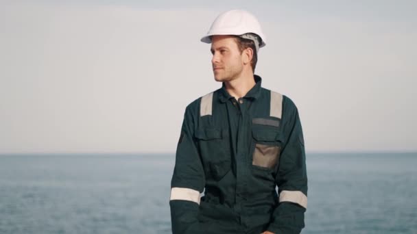 Joven hombre guapo operario de puerto con radio walkie-talkie en la mano trabajando en el puerto marítimo — Vídeo de stock