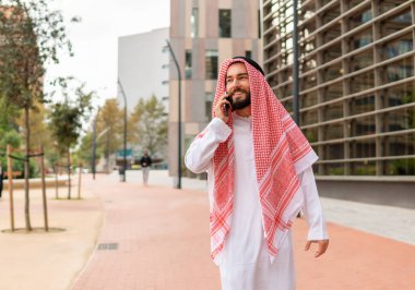 Sokakta akıllı telefondan konuşan bir Arap.