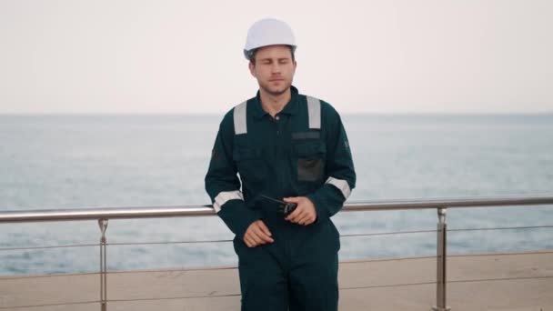 Havenwerker meldt status van lading door walkietalkie radio tijdens het werken in zeehaven — Stockvideo