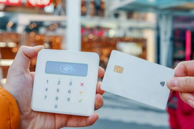 NFC ödemesini şehir merkezindeki POS terminalinde yapan plastik kartı olan tanınmayan bir müşteri.