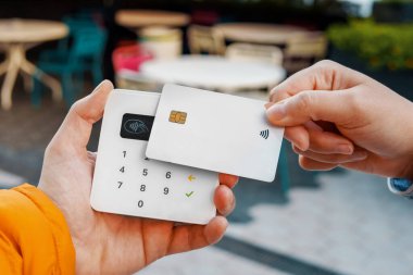 Kahve dükkanında bağlantısız ödeme yaparken kredi kartını kullanan tanınmayan bir müşteri.