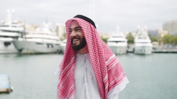 Hombre árabe alegre caminando en el puerto — Vídeos de Stock