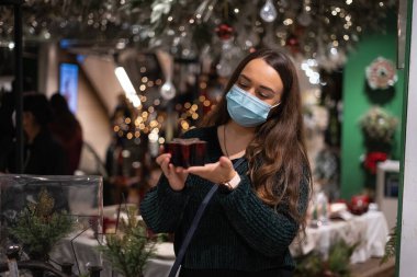 Alışveriş merkezindeki Noel süslerini inceleyen kadın.