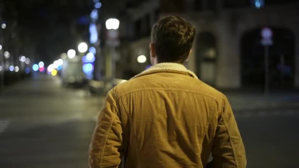 El hombre comienza a cruzar la calle por la noche — Vídeos de Stock